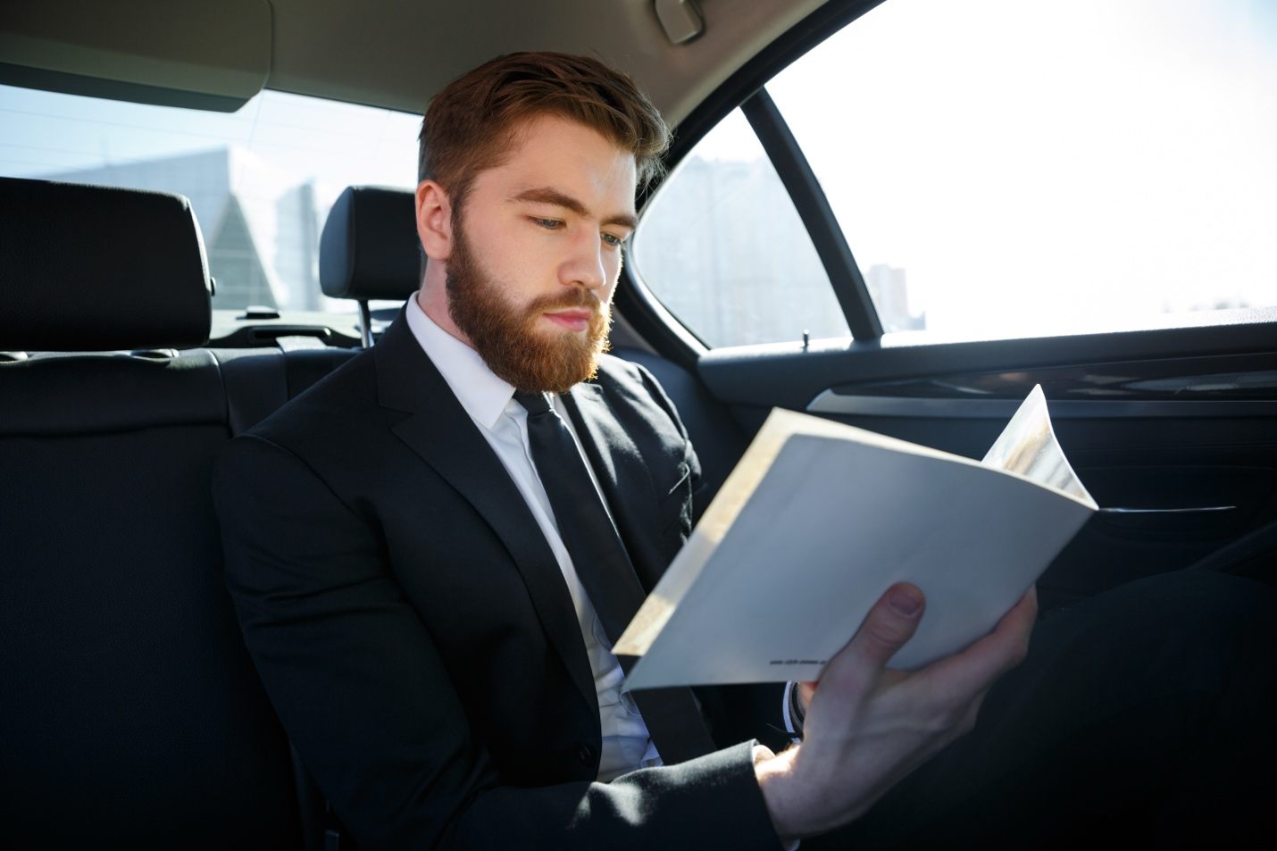 Passenger reading in luxury vehicle